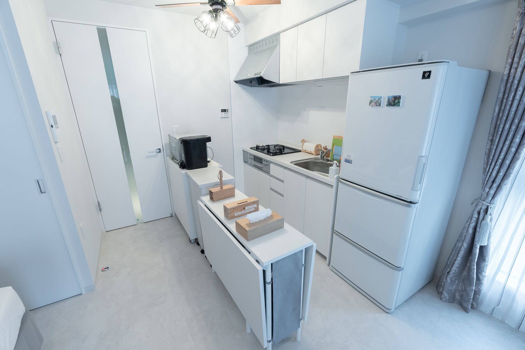 Eine kleine Küche mit Kühlschrank, Herd und Geschirrspüler.