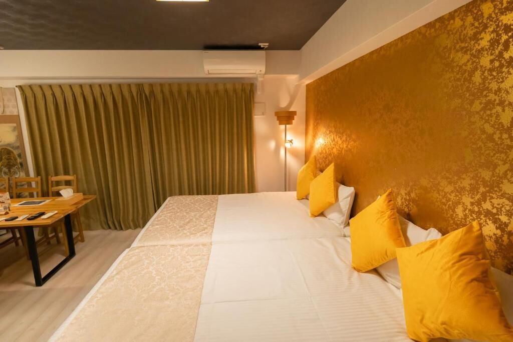 Una habitación de hotel con una cama, una mesa y sillas, y una cortina.
