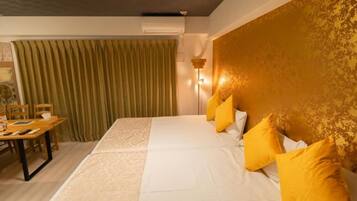 Una habitación de hotel con una cama, una mesa y sillas, y una cortina.