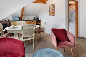 Ein Essbereich mit einem runden Tisch, Stühlen und einer Küche im Hintergrund.