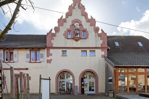 Un edificio con uno stile architettonico tradizionale, caratterizzato da finestre ad arco e una statua centrale.