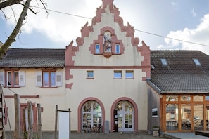 A building with a traditional architectural style, featuring arched windows and a central statue.