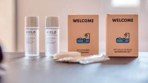 Two bottles of body wash and two welcome boxes on a table.