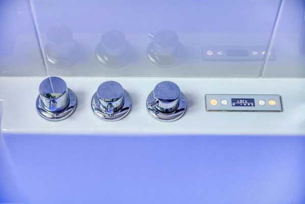 A control panel with three knobs and a digital display.