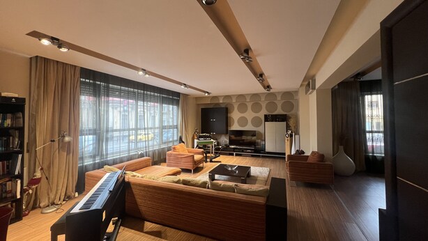 Una sala de estar moderna con un piano, sofá y mueble de entretenimiento.