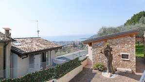 A residential property with a stone wall, a tree, and a view of the sea.