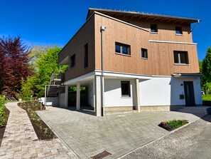 Un bâtiment moderne à deux étages, doté d’une façade en bois et d’un toit plat.