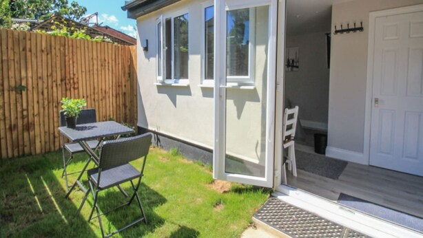 A residential property with a patio, a wooden fence, and a door leading to an enclosed space. - Modern London Studio 15mins to Central London (London)