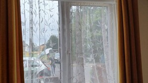A window with floral-patterned curtains, a view of a street with cars, and a potted plant on the windowsill. - Southampton 2-bedroom House (Southampton)
