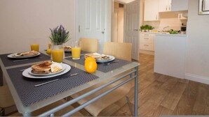 Ein Essbereich mit einem für das Frühstück gedeckten Tisch, darunter Teller mit Speisen und Orangensaft.