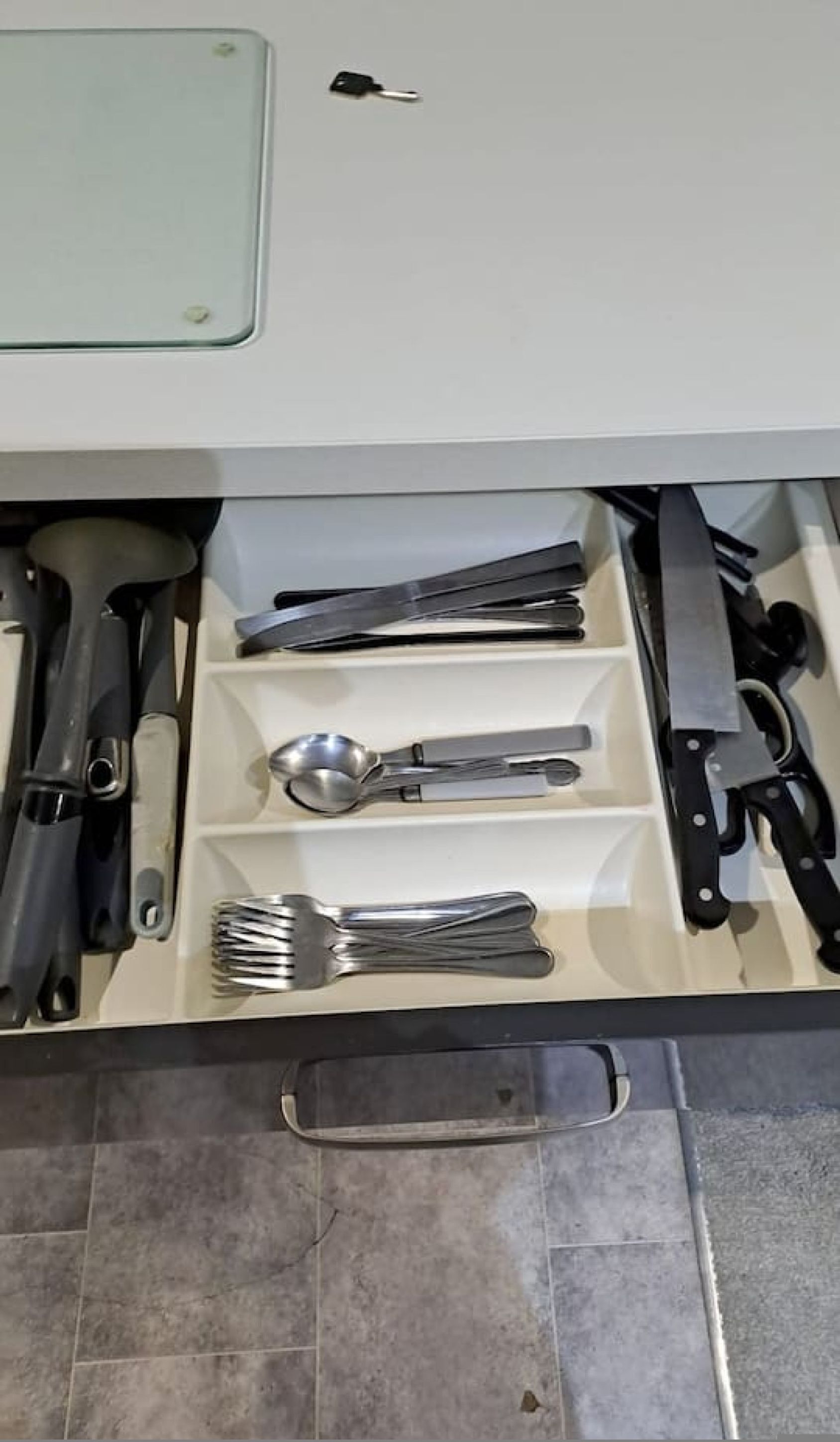Eine Küchenschublade mit Besteck, darunter ein Löffel, eine Gabel, ein Messer und ein Pfannenwender.