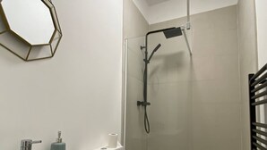 A bathroom with a shower, a toilet, and a sink. - Charming Bedford Apartment 1 Near Bedford Park (Bedford)