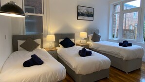 A hotel room with two beds, a large window, and a painting on the wall. - Charming Bedford Apartment 1 Near Bedford Park (Bedford)