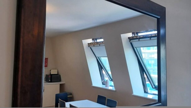 A room with a large mirror, a table, two chairs, and two windows with blinds. - Comfortable Southampton Stay (Southampton)