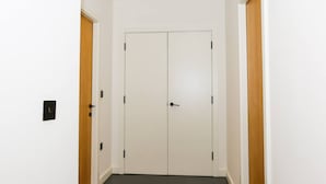 A hallway with a double door, a light switch, and a wooden trim on the walls. - Nichols Building City Escape Spacious 3BR Sheffield (Sheffield)