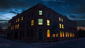 A historic red brick building with illuminated windows, a street sign, and a clear sky. - Nichols Building City Escape Spacious 3BR Sheffield (Sheffield)
