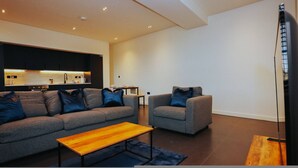 A modern living room with a sofa, armchair, and coffee table. - Nichols Building City Escape Spacious 3BR Sheffield (Sheffield)