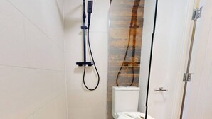 A modern bathroom with a shower, toilet, and a glass partition. - Stylish Bedford Town Centre Apartment 5 Sleeps 6 Fast Wi-fi (Bedford)