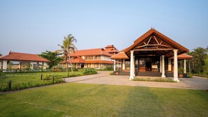 A resort with a covered pavilion, multiple buildings with red roofs, and a well-maintained lawn. - VIHARA By CMK (Kanayannur)