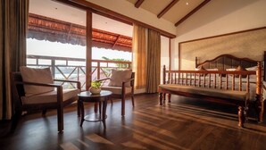 A room with a wooden bench, two armchairs, a small table with a plant, and a large window with a view. - VIHARA By CMK (Kanayannur)