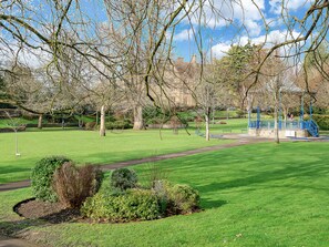 A park with green grass, trees, benches, and a blue staircase. - Central Sherborne (Sherborne)
