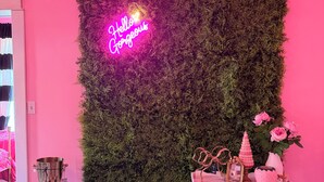 A room with a pink wall, a neon 'Hello Gorgeous' sign, a checkered floor, and a small table with decorative items. - Beautiful Creekside loft over Historic Mannington  (Mannington)