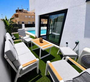 A rooftop terrace with white lounge chairs, a small table, and a view of the sea. - Casa Salina del Sol – Private Pool & Terrace (San Pedro del Pinatar)