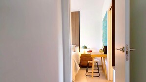 A hotel room with a bed, a desk, a chair, a lamp, and a wall-mounted shelf. - Casa Salina del Sol – Private Pool & Terrace (San Pedro del Pinatar)