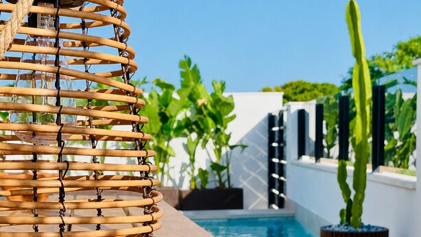 A wicker chair by a poolside with a cactus plant in the background. - Casa Salina del Sol – Private Pool & Terrace (San Pedro del Pinatar)