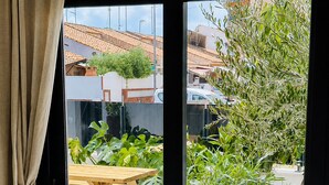 A room with a view of a patio area featuring a wooden table and potted plants. - Casa Salina del Sol – Private Pool & Terrace (San Pedro del Pinatar)