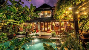 A traditional house with a pool, surrounded by lush greenery and illuminated by string lights. - Airlangga Dsawah by Balihora, Ubud Vill (Ubud)