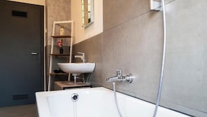A modern bathroom with a bathtub, a sink, and a shower. - Apartment Fioranza Comfortable stylish apartment for 6 people (Mülheim an der Ruhr)
