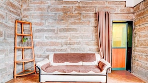 Una habitación con un sofá blanco, una escalera de madera y una pared de ladrillo.