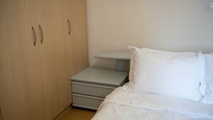 A bedroom with a bed, a nightstand, and a wardrobe. - Loucas Home Kalloni Lesvos Central Stay w Balcony (Lesvos)