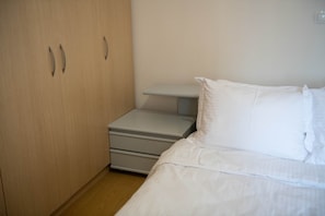 Una camera da letto con un letto, un comodino e un armadio.