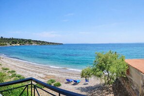 A beach with clear blue water, a sandy shore, and a few blue chairs. - Beachfront Modern Escape Anatoli By The Lesvos Sea (Lesvos)