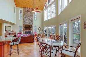 A spacious living area with a stone fireplace, wooden ceiling, and large windows. - On 80 Acres! Rural 'sunset Lodge' in Hot Springs (Hot Springs)