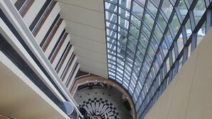 Un atrio espacioso con techos altos y un diseño circular central, amplias ventanas y un estilo arquitectónico moderno.