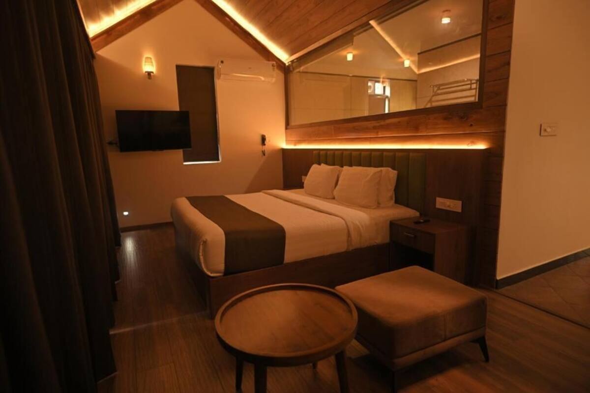 Een slaapkamer met een bed, nachtkastje en een ronde tafel.