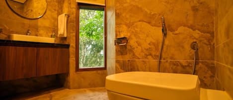 A bathroom with a toilet, a sink, a mirror, and a shower.