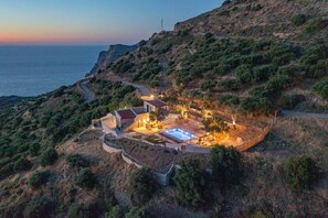 A coastal property with a swimming pool, multiple buildings, and a surrounding landscape. - Villa Maestoso - Private olive grove - Pool (Mirsini)