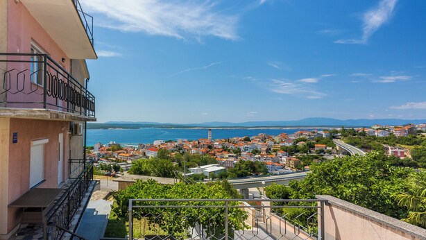 A balcony with a view of a coastal town, a clear sky, and distant mountains. - Modern vacation apartment with sea view (Crikvenica)