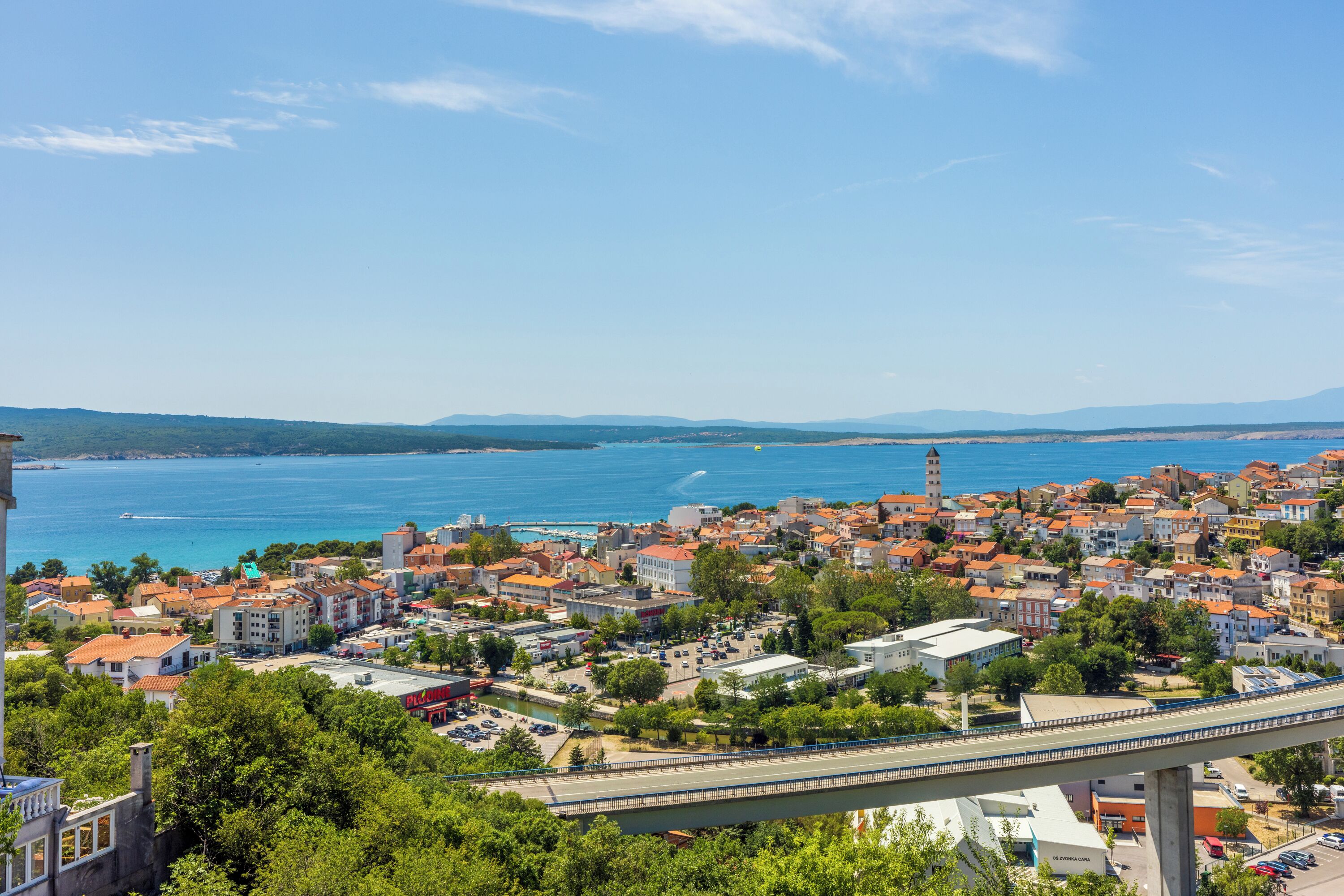 Une ville côtière avec un pont, des bâtiments et une vue sur la mer.