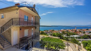 A multi-story building with a balcony, a staircase, and a view of a coastal town. - Modern vacation apartment with sea view (Crikvenica)
