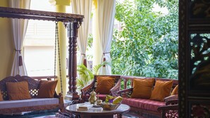 A traditional room with a sofa set, a coffee table, and a hanging chair. - Alaya Stays 4 BHK with Outdoor Dining Area - Abhimanyu Mansion Sapphire (Udaipur)