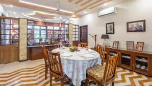 A dining area with a round table set for four, surrounded by wooden chairs. - Alaya Stays 4 BHK with Outdoor Dining Area - Abhimanyu Mansion Sapphire (Udaipur)
