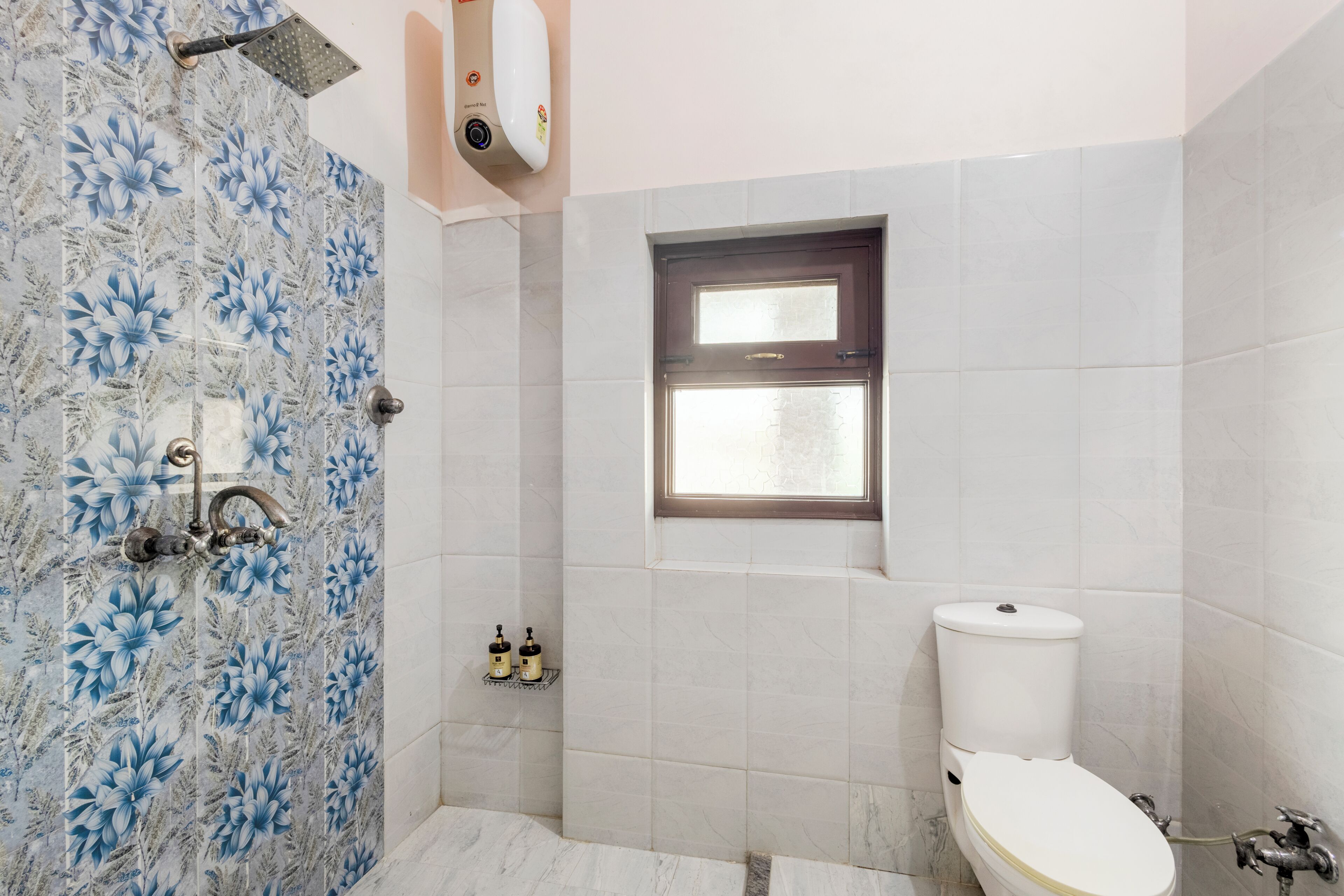 Une salle de bain avec une douche, des toilettes et une fenêtre.