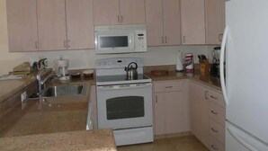 A kitchen with a microwave, oven, sink, and refrigerator. - 2br Oceanfront Loft With Solar Shade - Unit C27 1 Bedroom Condo (Lahaina)