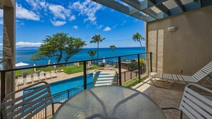 A balcony with a view of the ocean, a pool, and lounge chairs. - Prime Oceanfront 2br Loft - Unit C10 1 Bedroom Condo (Lahaina)