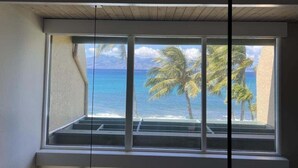 A window with a view of the ocean and palm trees. - Napili Point Point Oceanfront 2br Loft - Unit C2 1 Bedroom Condo (Lahaina)